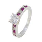 Yuki luxurious red gemstone ring with central clear diamond and alternating red gemstones on band